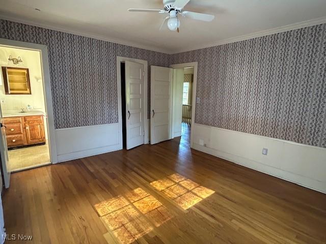 175 Curtis Dr, Avon Lake, OH 44012 - unfurnished bedroom with wallpapered walls, wood finished floors, crown molding, ceiling fan, and connected bathroom