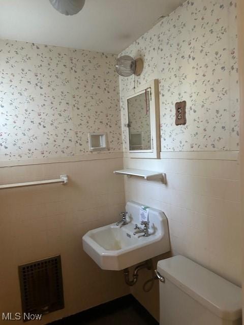 175 Curtis Dr, Avon Lake, OH 44012 - half bathroom featuring wallpapered walls and a wainscoted wall