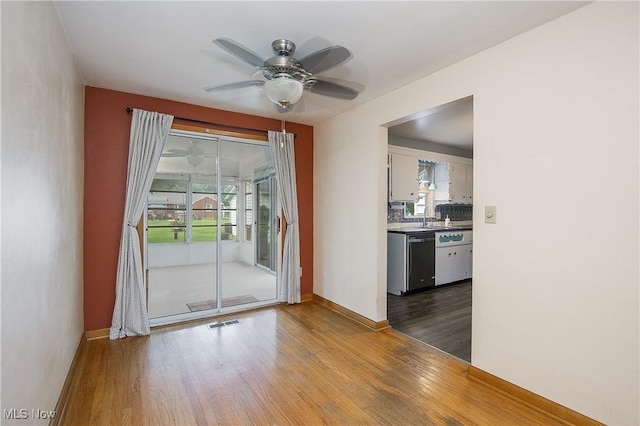 8298 Walter St NW, Massillon, OH 44646 - spare room featuring healthy amount of natural light, wood finished floors, and a ceiling fan