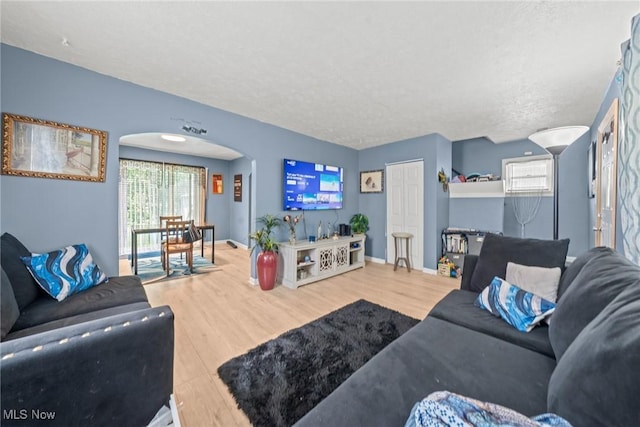 782 Ardella Ave, Akron, OH 44306 - living room featuring arched walkways, wood finished floors, and a textured ceiling