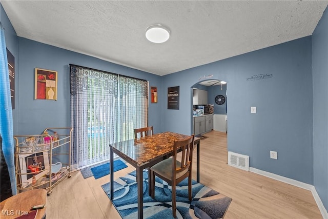 782 Ardella Ave, Akron, OH 44306 - dining room with arched walkways, wood finished floors, and a textured ceiling