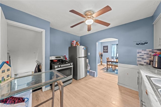 782 Ardella Ave, Akron, OH 44306 - kitchen with appliances with stainless steel finishes, a ceiling fan, light wood-style flooring, and arched walkways
