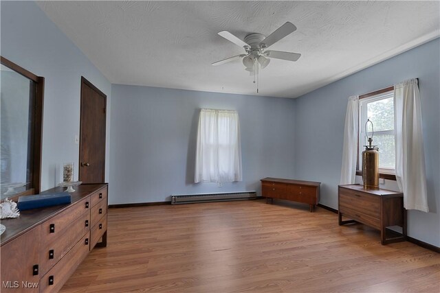 6414 Elk Rd, Canfield, OH 44406 - unfurnished bedroom with a baseboard heating unit, light wood-style flooring, and a ceiling fan