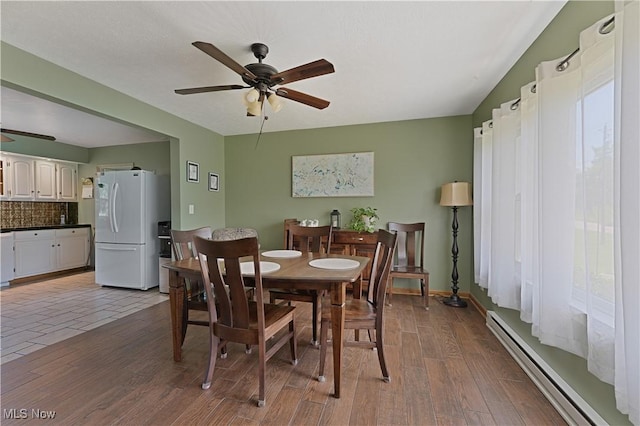6414 Elk Rd, Canfield, OH 44406 - dining area featuring a baseboard radiator, a ceiling fan, and wood finished floors