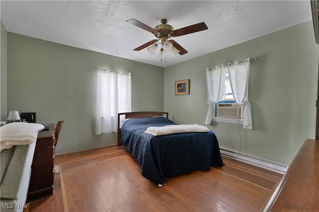 6414 Elk Rd, Canfield, OH 44406 - bedroom featuring baseboard heating, cooling unit, hardwood / wood-style flooring, a textured ceiling, and a ceiling fan