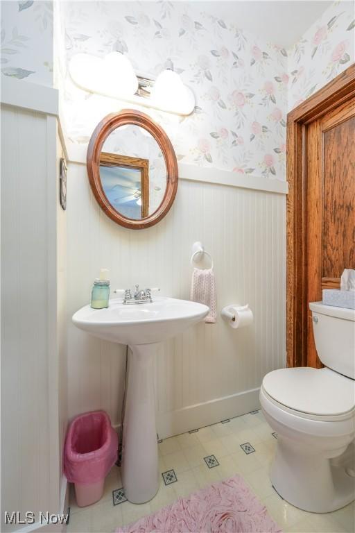 312 S Cleveland Ave, Mogadore, OH 44260 - half bath featuring wallpapered walls, wainscoting, and tile patterned floors
