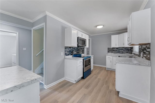 2413 W Manor Ave, Struthers, OH 44514 - kitchen featuring stainless steel appliances, decorative backsplash, light wood-type flooring, white cabinetry, and light countertops