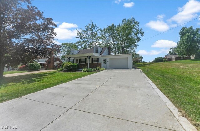 2413 W Manor Ave, Struthers, OH 44514 - cape cod home featuring driveway, a garage, a front yard, and a porch