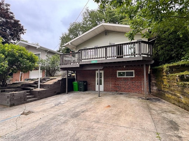 1587 Hilda St, Lakemore, OH 44250 - view of front of property with a deck, brick siding, stairs, and a patio