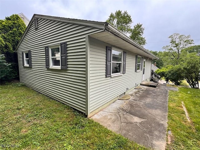 1587 Hilda St, Lakemore, OH 44250 - view of property exterior with a lawn and a patio
