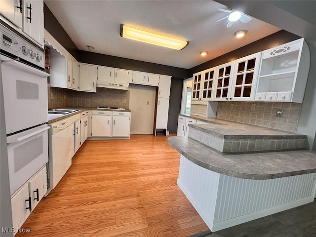 1587 Hilda St, Lakemore, OH 44250 - kitchen featuring white appliances, a peninsula, under cabinet range hood, decorative backsplash, and dark countertops