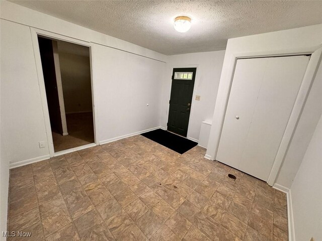 1587 Hilda St, Lakemore, OH 44250 - entrance foyer with a textured ceiling and stone finish flooring