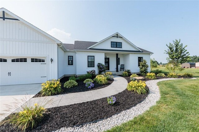 3508 Boos Rd, Huron, OH 44839 - modern inspired farmhouse with an attached garage, driveway, covered porch, and a front yard