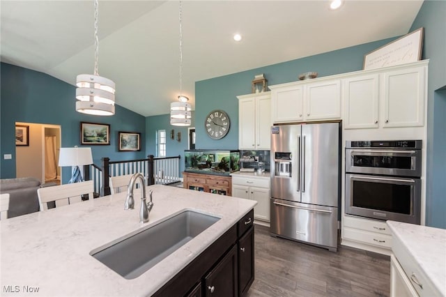 3508 Boos Rd, Huron, OH 44839 - kitchen with appliances with stainless steel finishes, vaulted ceiling, dark wood-style flooring, light stone countertops, and hanging light fixtures