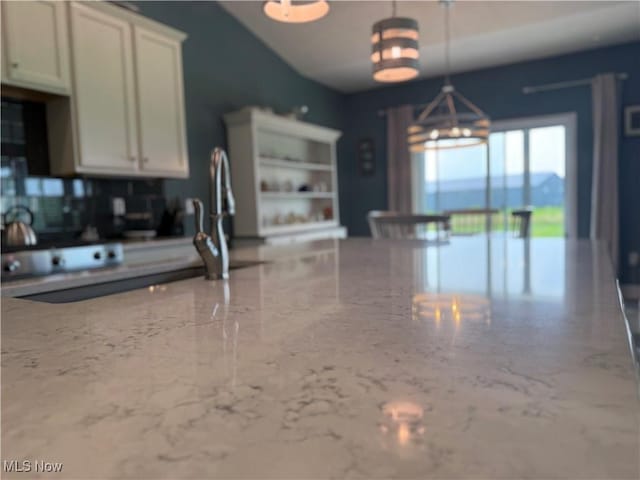 3508 Boos Rd, Huron, OH 44839 - kitchen featuring a chandelier, light stone counters, decorative light fixtures, white cabinets, and tasteful backsplash