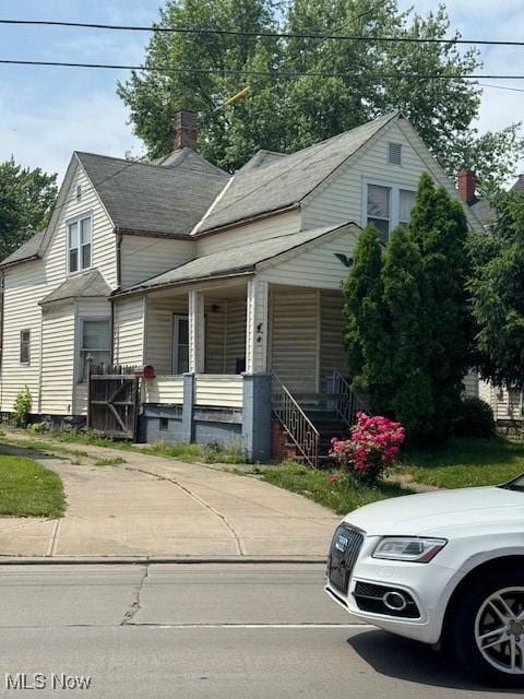 3454 Fulton Rd, Cleveland, OH 44109 - view of front facade with covered porch and a chimney
