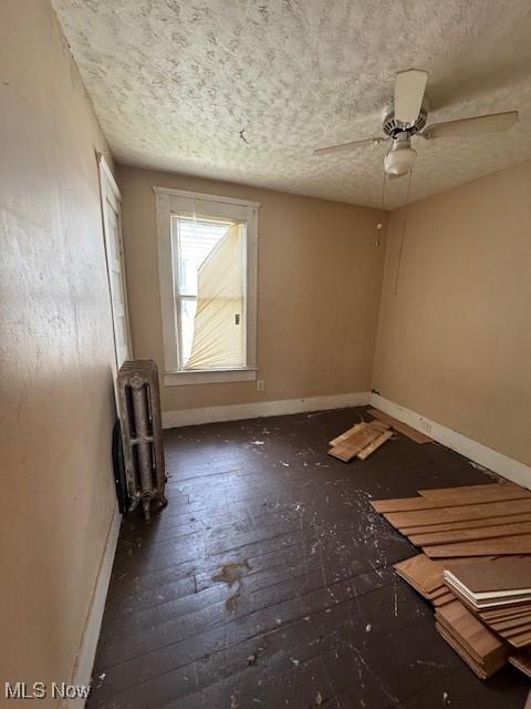 3454 Fulton Rd, Cleveland, OH 44109 - spare room with radiator, a ceiling fan, and a textured ceiling