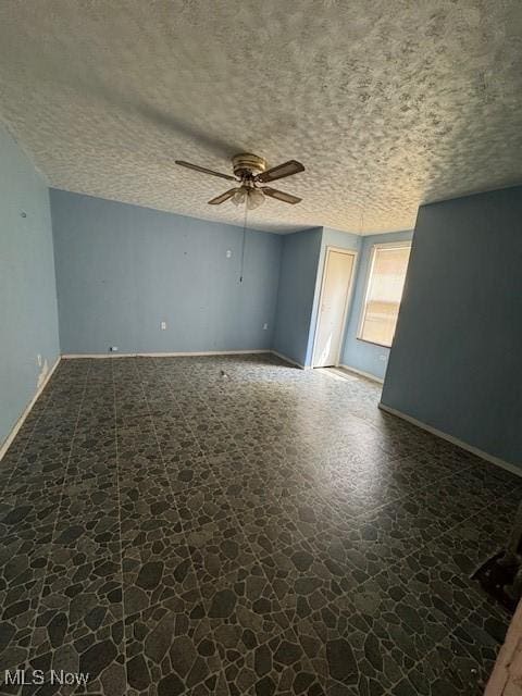 3454 Fulton Rd, Cleveland, OH 44109 - unfurnished room featuring a ceiling fan, a textured ceiling, and dark stone finish floors
