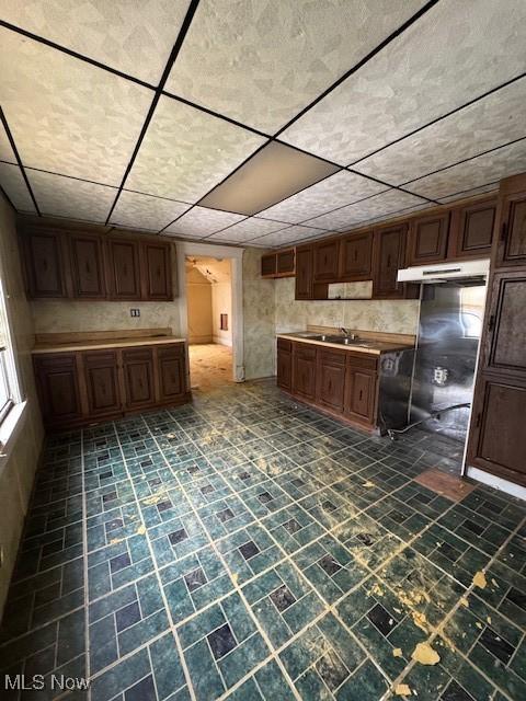 3454 Fulton Rd, Cleveland, OH 44109 - kitchen featuring under cabinet range hood, light countertops, and a drop ceiling