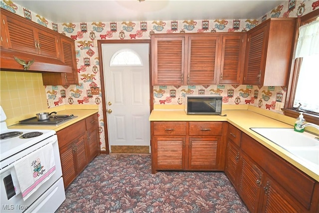 5735 Herbert Rd, Canfield, OH 44406 - kitchen featuring wallpapered walls, white range with electric cooktop, black microwave, light countertops, and under cabinet range hood