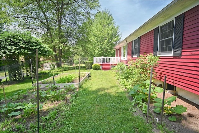 5735 Herbert Rd, Canfield, OH 44406 - view of green lawn with a vegetable garden and a wooden deck