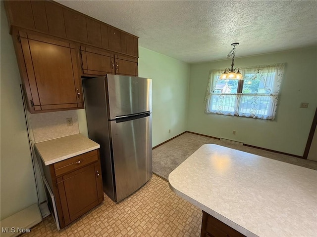 122 N Fairview Ave, Dover, OH 44622 - kitchen with freestanding refrigerator, light countertops, a textured ceiling, decorative light fixtures, and dark brown cabinetry