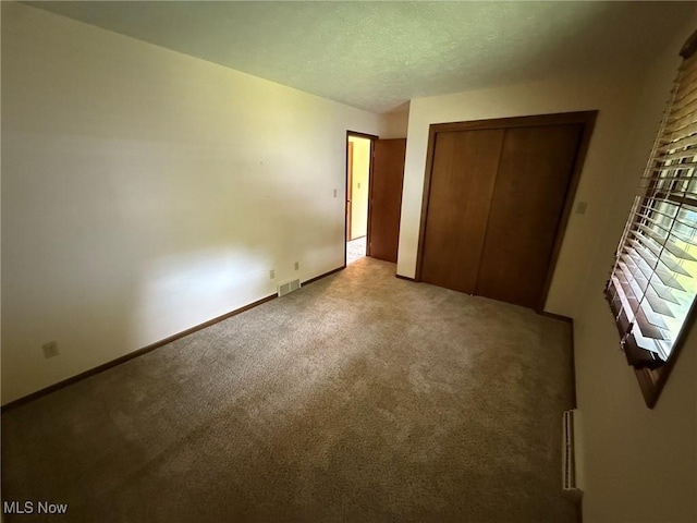 122 N Fairview Ave, Dover, OH 44622 - unfurnished bedroom featuring carpet, a closet, and a textured ceiling