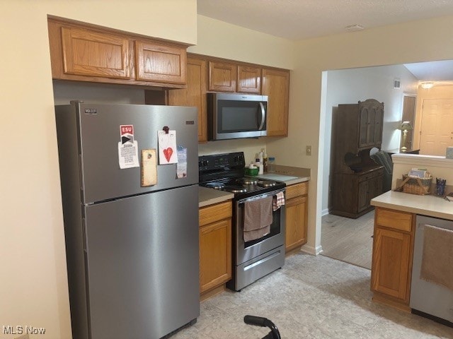 209 Potters Cir, Girard, OH 44420 - kitchen with stainless steel appliances, brown cabinets, and light countertops