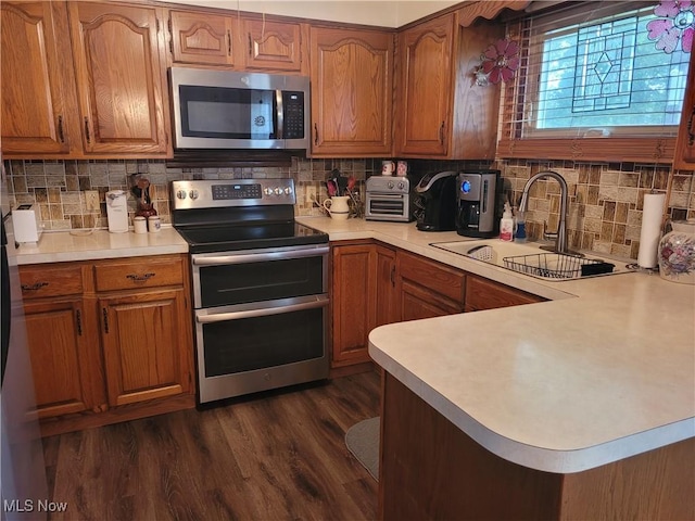 6412 Lieb Dr, New Franklin, OH 44216 - kitchen featuring appliances with stainless steel finishes, brown cabinetry, light countertops, and tasteful backsplash