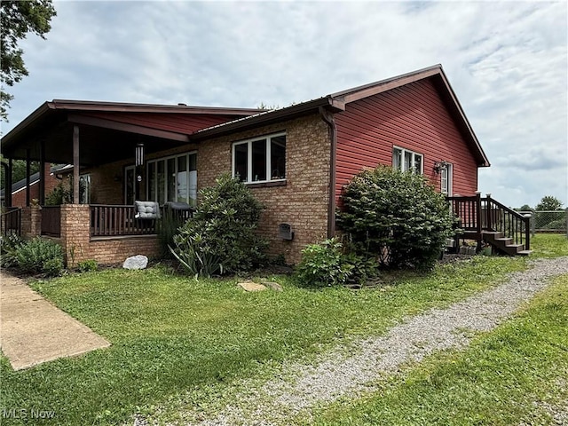 430 County Road 47, Toronto, OH 43964 - view of home's exterior featuring a lawn, brick siding, and a porch