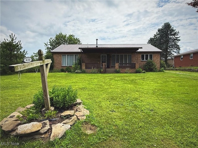 430 County Road 47, Toronto, OH 43964 - rear view of property with covered porch, a lawn, brick siding, and a metal roof