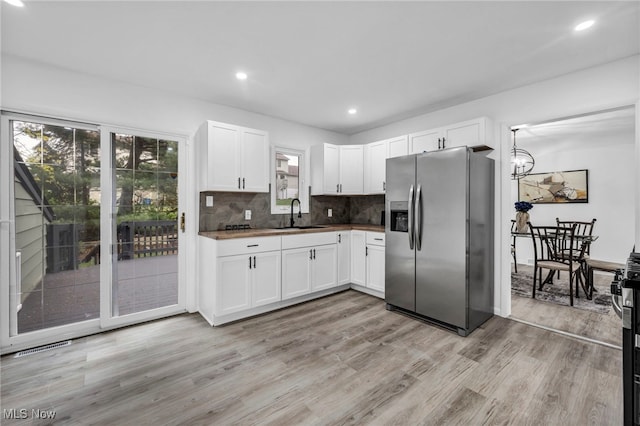 2162 Daniels Ave, Akron, OH 44312 - kitchen featuring stainless steel fridge, light wood-type flooring, backsplash, white cabinets, and recessed lighting