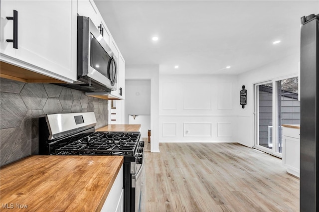 2162 Daniels Ave, Akron, OH 44312 - kitchen with appliances with stainless steel finishes, butcher block countertops, white cabinets, light wood-type flooring, and recessed lighting