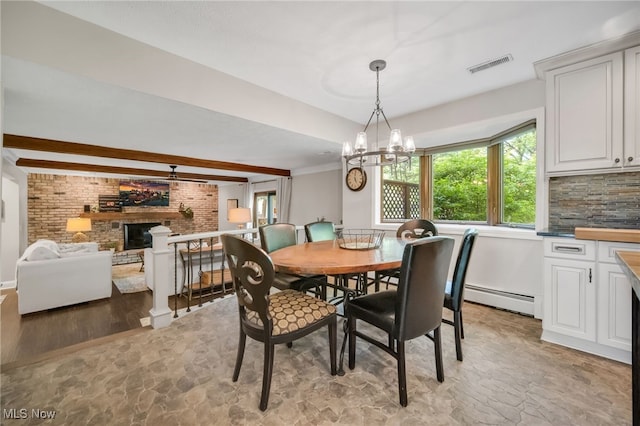 5108 Great Oaks Pkwy, Independence, OH 44131 - dining space with a baseboard heating unit, plenty of natural light, a chandelier, a brick fireplace, and brick wall