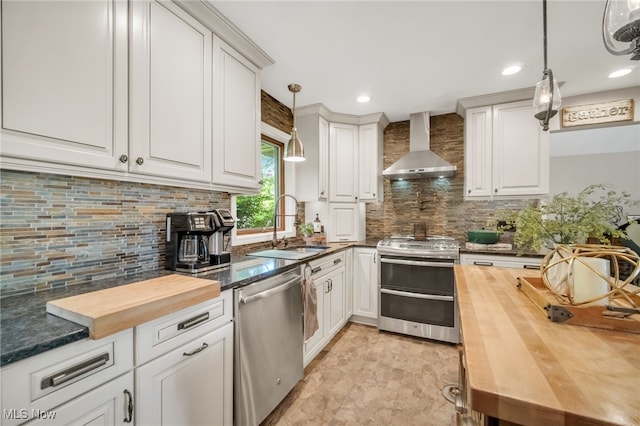 5108 Great Oaks Pkwy, Independence, OH 44131 - kitchen featuring wall chimney exhaust hood, appliances with stainless steel finishes, wood counters, decorative backsplash, and white cabinetry