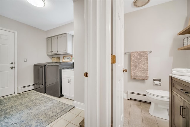5108 Great Oaks Pkwy, Independence, OH 44131 - laundry area featuring separate washer and dryer, baseboard heating, light tile patterned flooring, and cabinet space