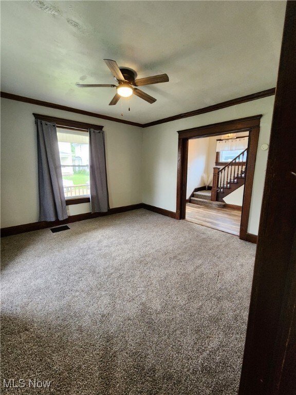600 Orchard Ave, Cambridge, OH 43725 - unfurnished room with carpet flooring, ceiling fan, crown molding, and stairway