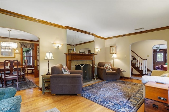 2925 Millboro Rd, Silver Lake, OH 44224 - living area with arched walkways, light wood finished floors, ornamental molding, a fireplace, and stairway