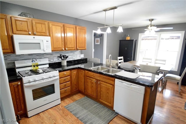 320 Lauretta Ln, Hubbard, OH 44425 - kitchen with white appliances, a peninsula, tasteful backsplash, dark countertops, and light wood finished floors