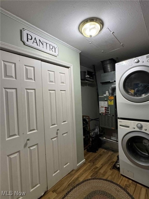 675 E 8th St, Salem, OH 44460 - washroom featuring stacked washer and clothes dryer, ornamental molding, dark wood-style flooring, and a textured ceiling