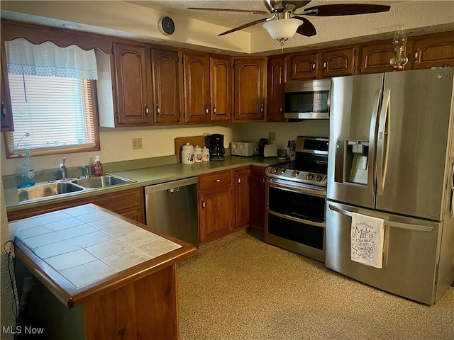 1321 Congo Arroyo Rd, New Cumberland, WV 26047 - kitchen featuring appliances with stainless steel finishes, tile counters, a ceiling fan, and brown cabinets