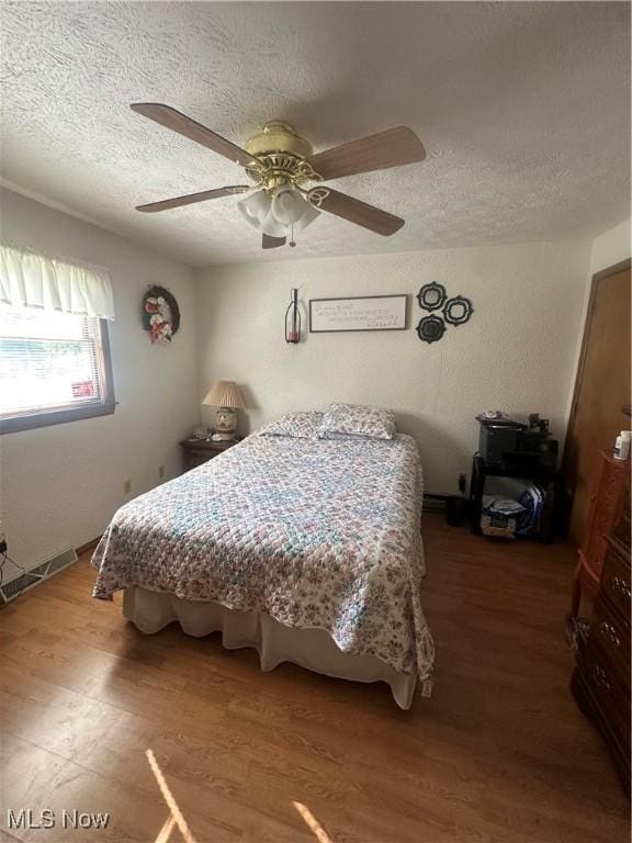 1321 Congo Arroyo Rd, New Cumberland, WV 26047 - bedroom featuring wood finished floors, a textured ceiling, and a ceiling fan