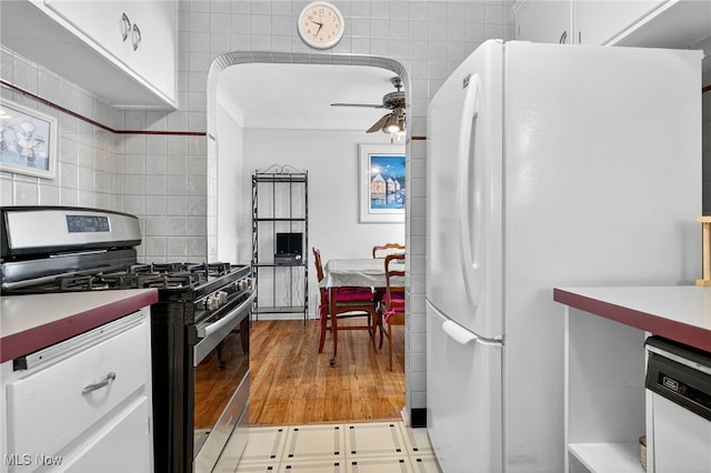 4095 W 161st St, Cleveland, OH 44135 - kitchen with white appliances, a ceiling fan, white cabinets, decorative backsplash, and light wood-type flooring