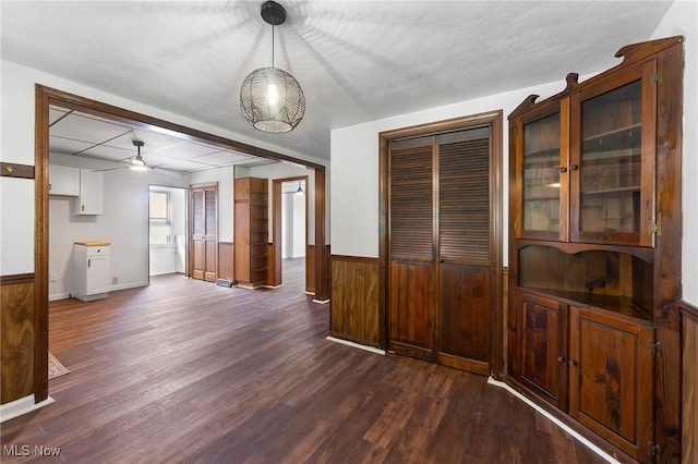 160 State St, Struthers, OH 44471 - unfurnished dining area featuring dark wood-style flooring, a ceiling fan, and a wainscoted wall