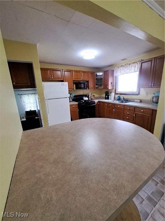 4016 State Route 7, Burghill, OH 44404 - kitchen with black appliances, light countertops, a peninsula, and brown cabinetry