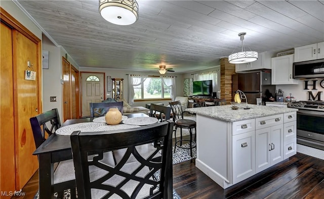 2463 NW Renner Dr NW, Dover, OH 44622 - kitchen featuring appliances with stainless steel finishes, dark wood-style floors, white cabinetry, and a kitchen island