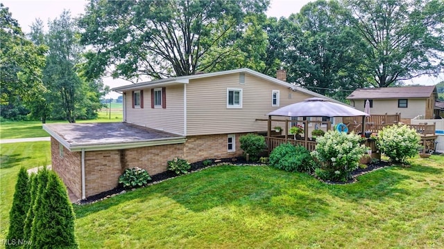 2463 NW Renner Dr NW, Dover, OH 44622 - back of house featuring a gazebo, a lawn, brick siding, a wooden deck, and a chimney