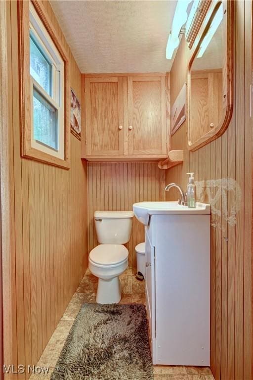 2463 NW Renner Dr NW, Dover, OH 44622 - half bathroom featuring vanity and wooden walls