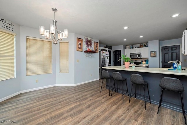 1005 Penn Ct, Grafton, OH 44044 - kitchen featuring stainless steel appliances, white cabinetry, a chandelier, wood finished floors, and recessed lighting