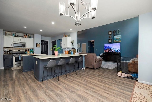 1005 Penn Ct, Grafton, OH 44044 - kitchen featuring appliances with stainless steel finishes, wood finished floors, open floor plan, recessed lighting, and white cabinets